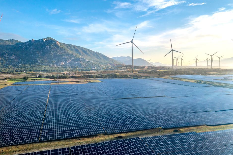 Solar farm and wind turbines at sunrise