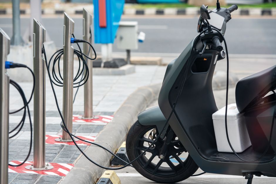 Electric scooter charging at a public charging bay
